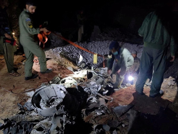People work around what Pakistani security sources say is the remains of a missile fired into Pakistan from India, near Mian Channu, Pakistan, March 9, 2022. Picture taken March 9, 2022. Pakistani security sources/Handout via REUTERS