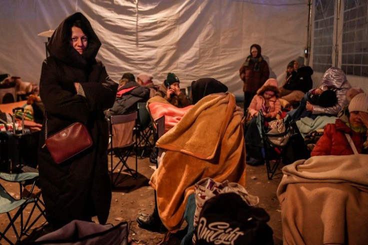 Refugees rest in a tent after crossing the Polish border
