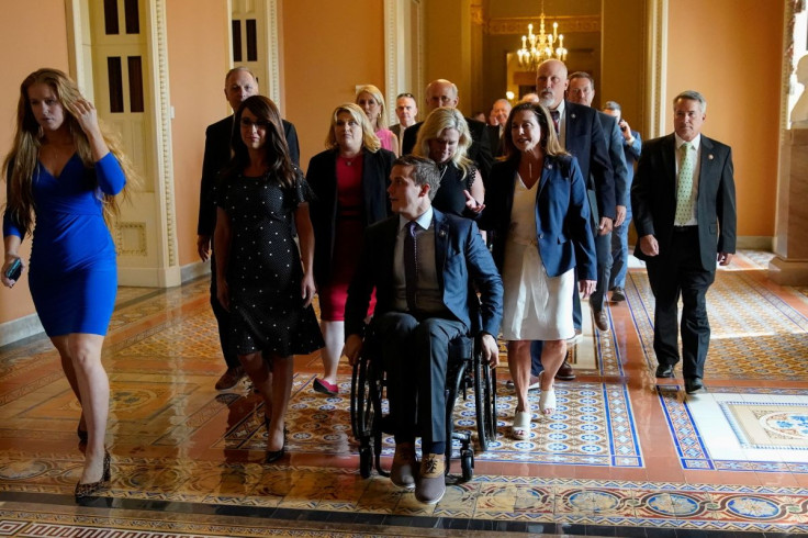 House Republicans, including Representatives Lauren Boebert (R-CO), Kat Cammack (R-FL), Madison Cawthorn (R-NC), Marjorie Taylor Greene (R-GA), Lisa McClain (R-MI) and Jody Hice (R-GA), who oppose mask mandates march as a group to the Senate chamber to hi