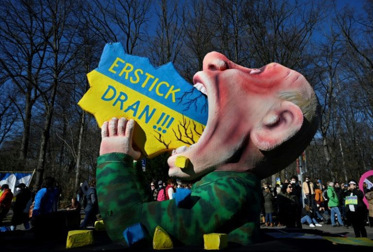 A giant figure representing Russian President Vladimir Putin swallowing a map of the Ukraine is seen during a demonstration in Berlin, the words read :"Choke on it!!!"