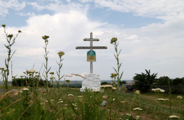 A view shows a cross near the crash site of Malaysia Airlines Flight MH17 plane, that was shot down over territory held by pro-Russian separatists in 2014, outside the village of Hrabove in Donetsk Region, Ukraine June 19, 2019. A sign on the cross reads