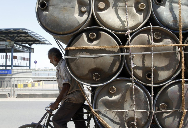 A man rides his trishaw loaded with empty plastic barrels which are used to carry oil in the western Indian city of Ahmedabad March 10, 2011.