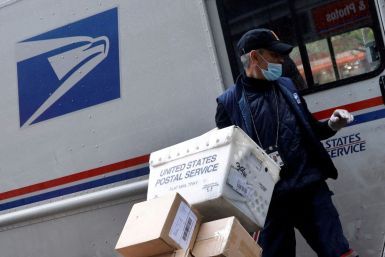 A United States Postal Service (USPS) worker unloads packages from his truck in Manhattan during the outbreak of the coronavirus disease (COVID-19) in New York City, New York, U.S., April 13, 2020. 