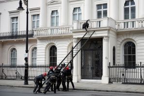A protestor tries to push away a ladder being used by police officers as they attempt to enter a building next to the mansion reportedly belonging to Russian billionaire Oleg Deripaska, who was placed on Britain's sanctions list last week, as squatters oc