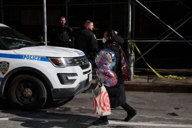 A woman walks with balloons by an area where NYPD police have marked off an area where a 43-year-old man was found dead on Sunday evening in New York City, U.S., March 14, 2022.