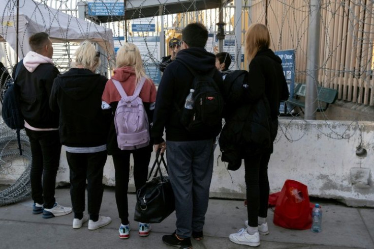 Ukrainians talk to a US border officer at the San Ysidro crossing in Tijuana in northwestern Mexico