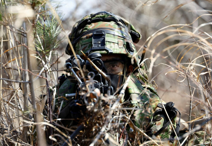 A member of the Japanese Self-Defense Forceâs Amphibious Rapid Deployment Brigade aims his gun as he takes a position during joint airborne landing exercises with the U.S.Marine Corps near Mount Fuji at Higashifuji training field in Gotemba, west of Tok