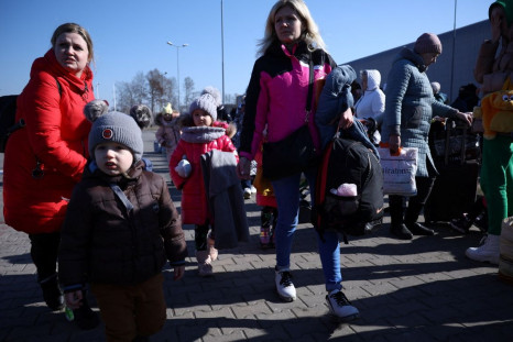 People walk in front of the reception center for refugees, following the Russian invasion of Ukraine, in Nadarzyn, Poland, March 14, 2022. Picture taken March 14, 2022. 