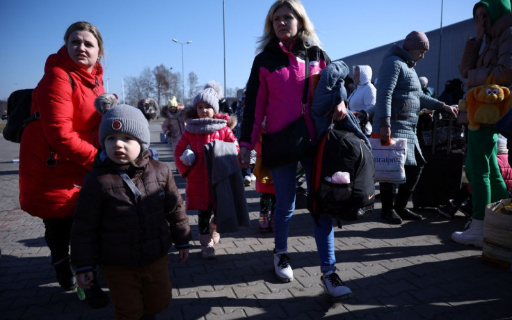 People walk in front of the reception center for refugees, following the Russian invasion of Ukraine, in Nadarzyn, Poland, March 14, 2022. Picture taken March 14, 2022. 