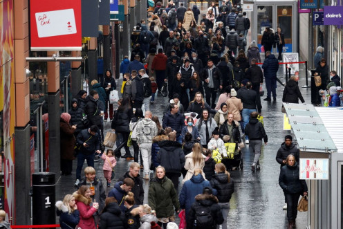 People walk along a busy shopping street as people look for bargains in the traditional Boxing Day sales in Liverpool, Britain, December 26 , 2021. 