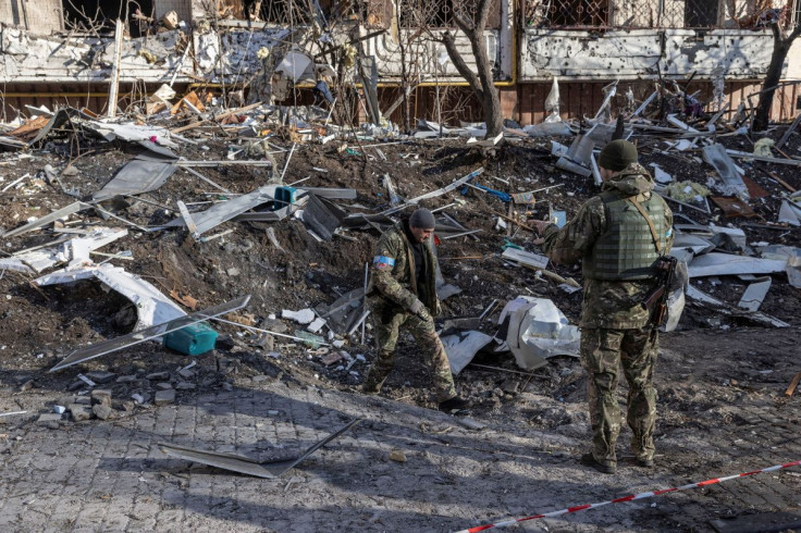 Ukrainian servicemen inspect the area in front of a residential apartment building after it was hit by shelling as Russia's invasion of Ukraine continues, in Kyiv, Ukraine, March 15, 2022.