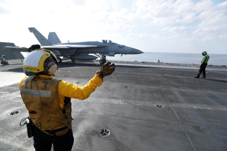 Shooter and Controler prepare an F/A-18E Super Hornet to be catapulted off from the flight deck of the aircraft carrier USS Abraham Lincoln in the Gulf, November 23, 2019. 