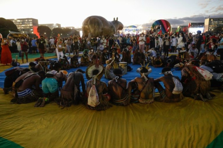 Indigenous people attend Brazilian musician Caetano Veloso's performance during a demo in defense of Earth and the environment and against the environmental policies of Brazilian President Jair Bolsonaro, outside Congressin Brasilia, on March 9, 2022, as