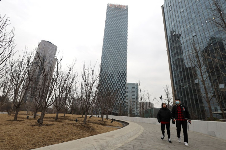 People walk past a building of Greenland Holdings Corp. Ltd. in Beijing, China March 11, 2022.