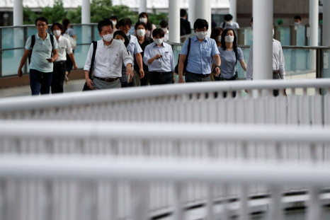 Office workers wearing protective face masks head home during the spread of the coronavirus disease (COVID-19), at a station in Tokyo, Japan June 24, 2020.  