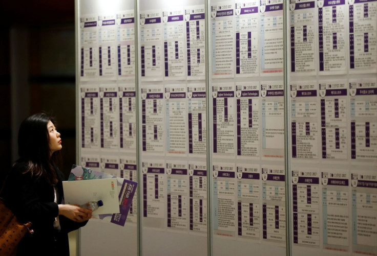 A woman looks at recruiting information during a job fair in Seoul, South Korea, April 12, 2017.  