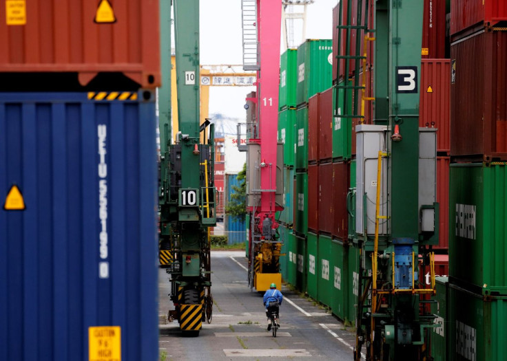 A man in a bicycle drives past containers at an industrial port in Tokyo, Japan, May 22, 2019.