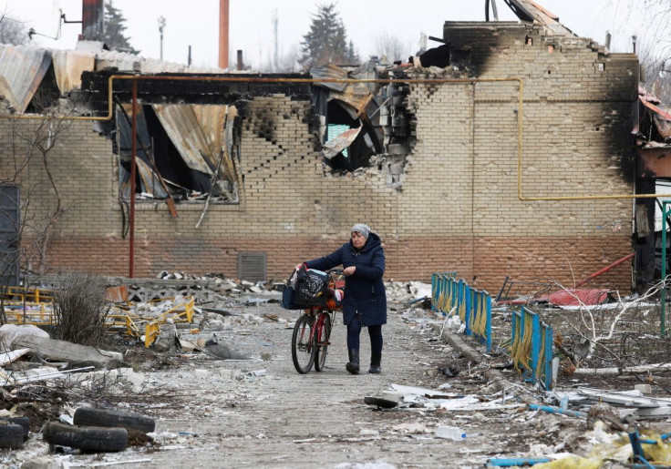 A woman walks with a bicycle next to a building damaged during Ukraine-Russia conflict in the separatist-controlled town of Volnovakha in the Donetsk region, Ukraine March 15, 2022. 