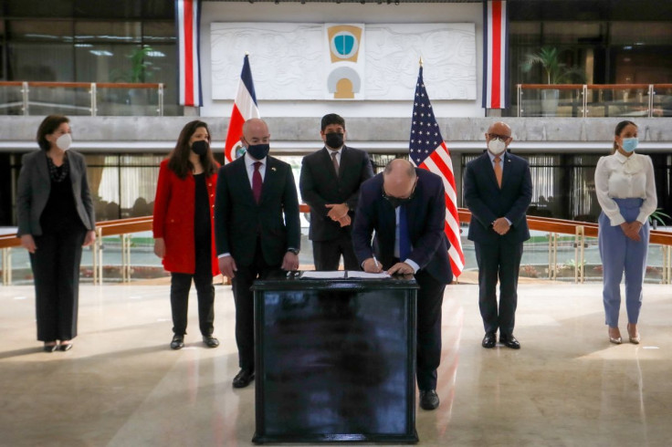 U.S. Homeland Security Secretary Alejandro Mayorkas and Costa Rica's President Carlos Alvarado Quesada look on as Costa Rica's Minister of Public Security Michael Soto signs bilateral documents during a meeting in San Jose, Costa Rica March 15, 2022. Cost