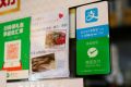 Logos for digital payment services Alipay by Ant Group, an affiliate of Alibaba Group Holding and WeChat Pay by Tencent Holdings are displayed outside a restaurant, in Hong Kong, China November 1, 2020. 