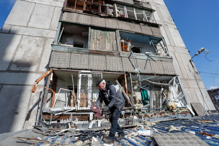 A man removes debris outside a residential building damaged by shelling during Ukraine-Russia conflict in the separatist-controlled town of Makeyevka (Makiivka) outside Donetsk, Ukraine March 16, 2022. 
