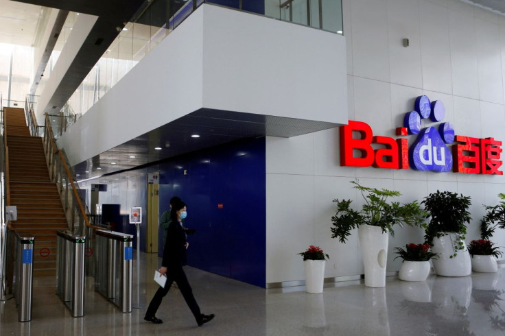 People walk near a Baidu logo at the company headquarters in Beijing, China April 23, 2021.