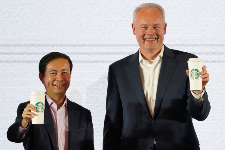 Starbucks CEO Kevin Johnson (R) and Chief Executive Officer of Alibaba Group Holding Ltd. Daniel Zhang hold cups of Starbucks for a picture at a strategic partnership press conference in Shanghai, China August 2, 2018. 