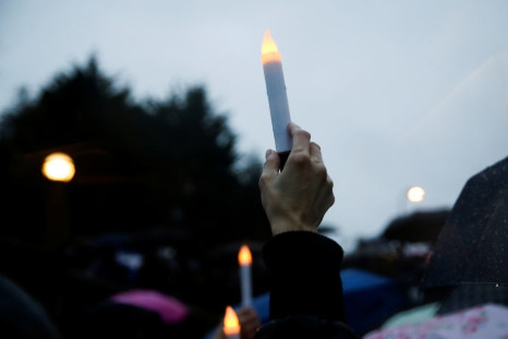A person holds a battery-powered candle in the rain during a "Stop Asian Hate" rally and vigil to remember the Atlanta shooting victims at Bellevue Downtown Park in Bellevue, Washington, U.S. March 20, 2021.  