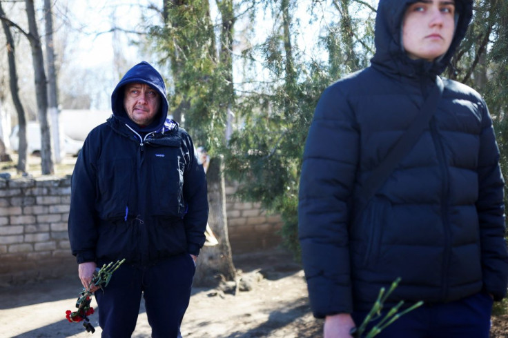 Relatives of Sergiy, 37, who is a Ukrainian deceased service member, hold flowers while waiting for his body at the morgue, as Russia's invasion of Ukraine continues, in Mykolaiv, Ukraine, March 16, 2022.