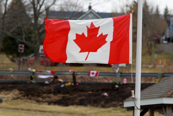 A Canadian flag flies at half-staff backdropped by the makeshift memorial for Royal Canadian Mounted Police (RCMP) Constable Heidi Stevenson, who was shot dead along with multiple others, in Shubenacadie, near Enfield, Nova Scotia, Canada April 22, 2020. 