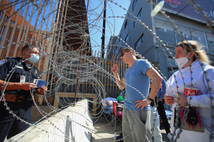 An U.S. Customs and Border Protection agent listens to Russians seeking for a humanitarian visa at the San Ysidro Port of Entry of the U.S.-Mexico border in Tijuana, Mexico March 15, 2022.