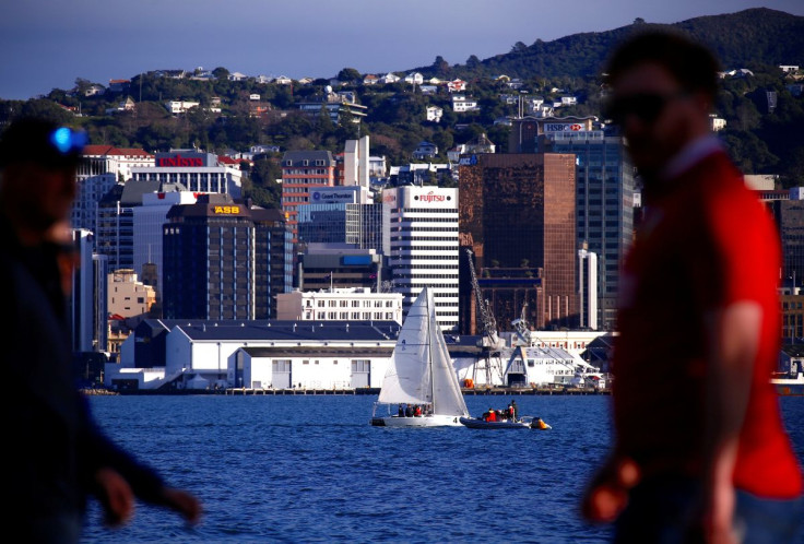 Pedestrians walk past a sailing boat as it passes in front of the central business district (CBD) of Wellington in New Zealand, July 2, 2017.