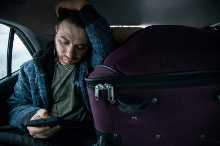 Vartan Davtian reads messages while riding in a car packed with supplies from his home in Brandon, Manitoba, to the Winnipeg airport to grab a flight to Europe and ultimately make his way to Ukraine