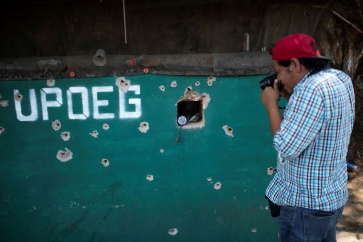 Lenin Ocampo photographs a bullet-pocked wall in the southern state of Guerrero after an attack by alleged members of a criminal group