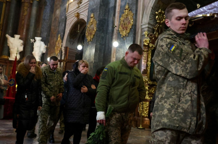 Family members and comrades mourn the death of Eduard Niezhenets, who was killed in a rocket attack against a military base in Yavoriv during the ongoing Russian invasion, during his memorial service at the Saints Peter and Paul Garrison Church in Lviv, U
