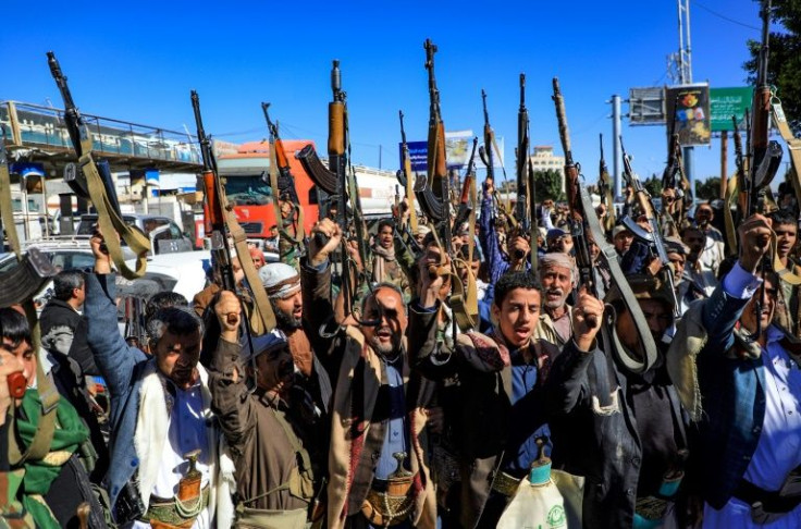 Yemeni supporters of the Iran-backed Huthi movement brandish their weapons as they rally in the capital Sanaa on January 27, 2022