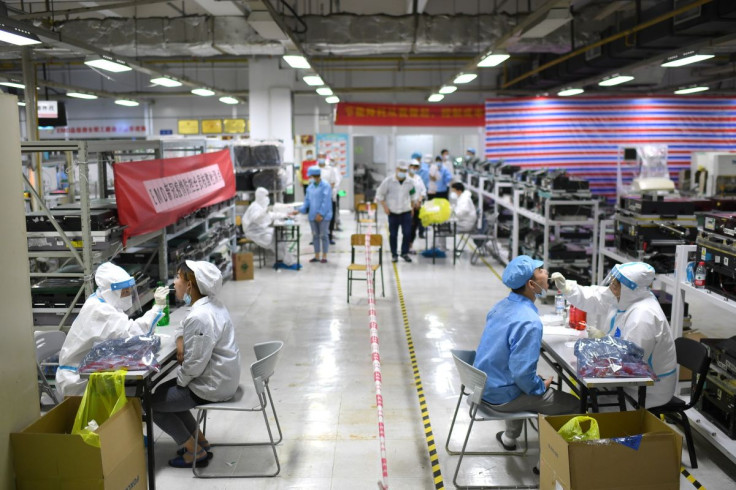 Medical workers in protective suits collect swabs from workers for nucleic acid testing at a Foxconn factory, following new cases of the coronavirus disease (COVID-19) in Wuhan, Hubei province, China August 5, 2021. China Daily via 