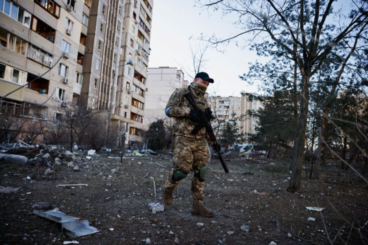 A member of the Ukrainian military surveys an area next to a residential building that was hit by an intercepted missile, as Russia's invasion of Ukraine continues, in Kyiv, Ukraine March 17, 2022. 