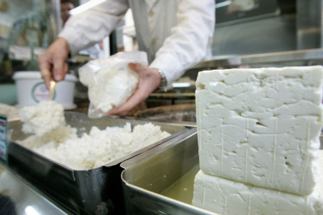 A cheesemonger puts pieces of Greece's trademark feta cheese in a bag for a customer in central Athens, November 21, 2007. 