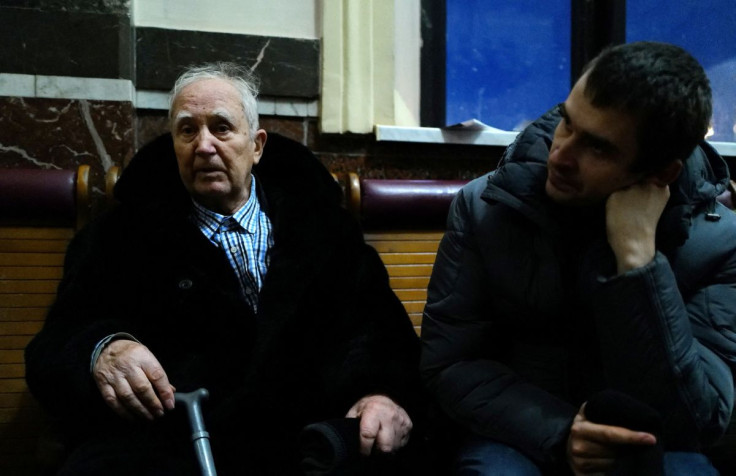 79-year old Boris Mosyir sits next to his son Ihor as they speak to Reuters about fleeing the ongoing Russian invasion, while resting inside the main train station in Lviv, Ukraine, March 14, 2022. Picture taken on March 14, 2022. 