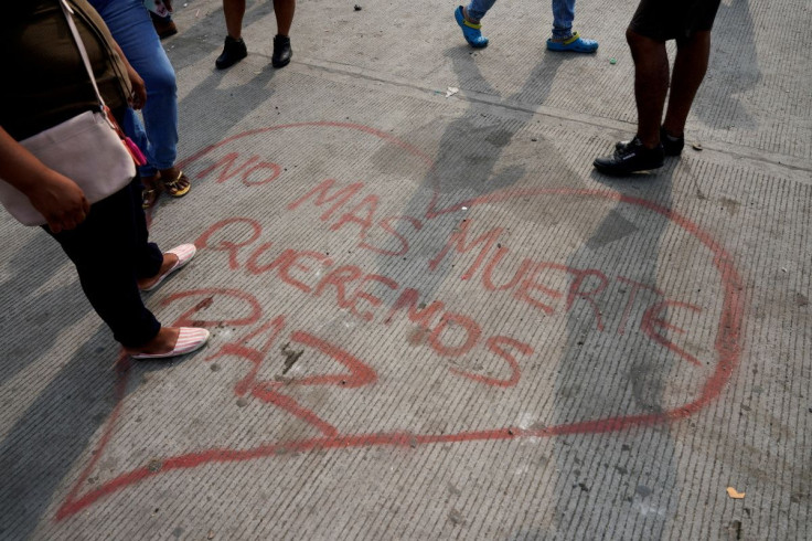 A slogan reads "not more death, we want peace" as family members gather outside Penitenciaria del Litoral prison where prisoners were killed and injured in overnight violence, in Guayaquil, Ecuador November 13, 2021.