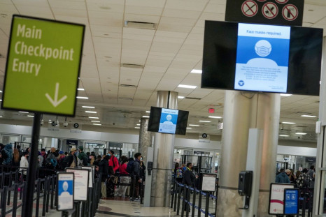 Signs informing passengers that face masks are mandatory are seen on screens at a security checkpoint at Hartsfield-Jackson Atlanta International Airport in Atlanta, Georgia, U.S. December 20, 2021. 