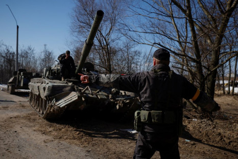A Ukrainian soldier directs a Russian tank that Ukrainians captured after fighting with Russian troops, as Russia's attack on Ukraine continues, outside Brovary, near Kyiv, Ukraine, March 10, 2022. 