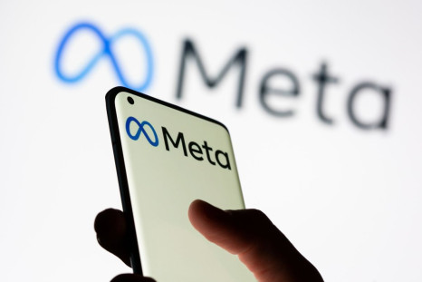 Woman holds smartphone with Meta logo in front of a displayed Facebook's new rebrand logo Meta in this illustration picture taken October 28, 2021. 