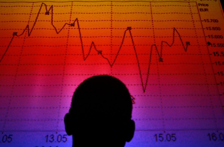 A man is silhouetted in an electronic board showing the FTSE MIB Index for the Italian equity market in this photo illustration taken in Rome August 9, 2011.