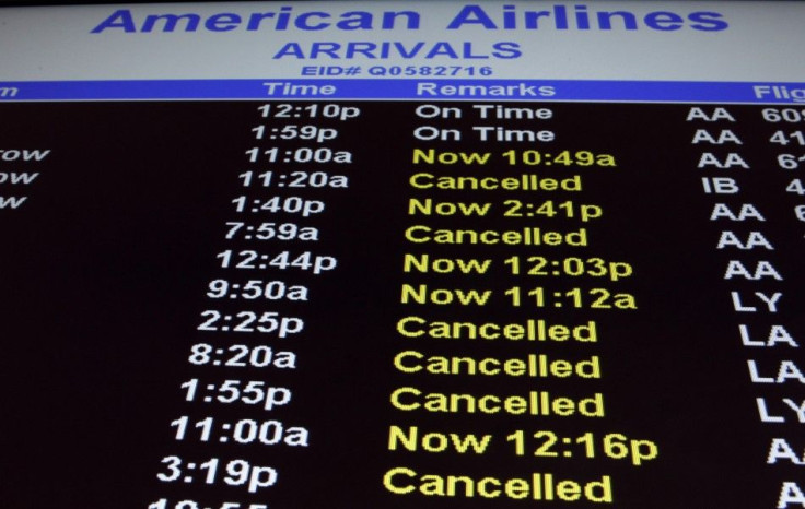 An arrivals board for American Airlines displays cancelled and delayed flights at the John F. Kennedy International Airport in New York