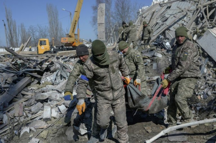 Ukrainian soldiers carried a comrade's body out of debris Saturday at a military school hit by Russian rockets in Mykolaiv.