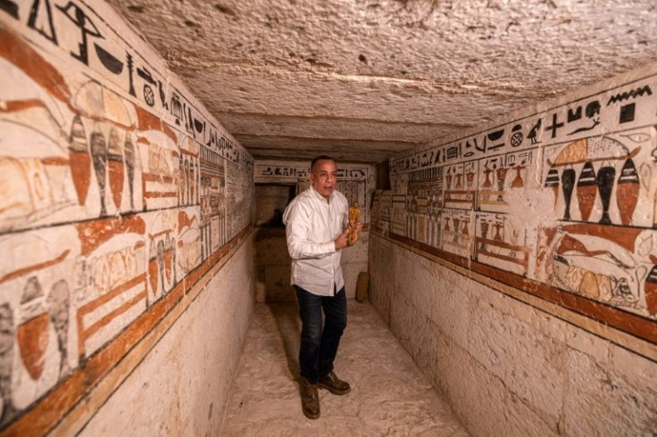 Mostafa Waziri, the head of Egypt's Supreme Council of Antiquities, holds a small statuette on March 19, 2022, inside one of the five ancient Pharaonic tombs recently discovered at the Saqqara archaeological site, south of the  capital Cairo