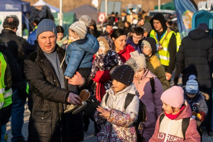 Refugees wait for a but to carry them onward after crossing the Ukrainian-Polish border in Medyka, southeastern Poland on March 19, 2022