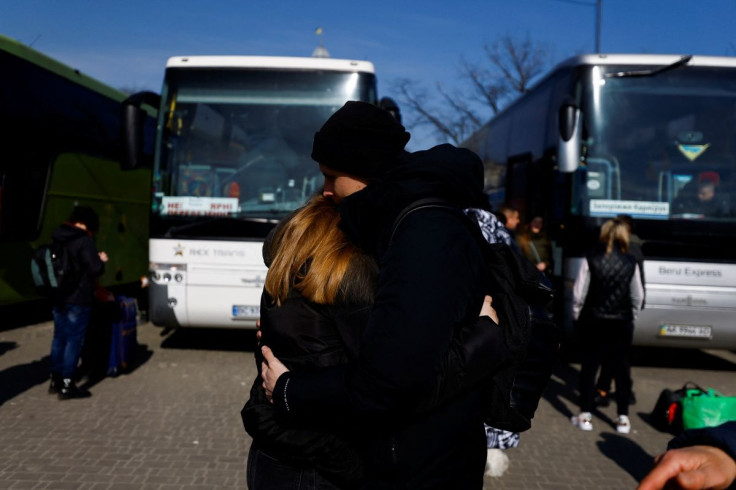 Olena, 26, from Kyiv  who is fleeing Russia's invasion of Ukraine, hugs her husband Oleksii, 27,  before she boards a bus heading to Stuttgart, in Germany outside the train station in Lviv, Ukraine March 20, 2022. 